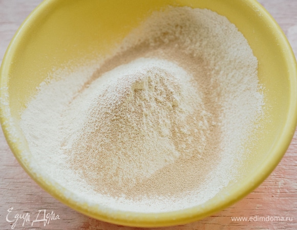 В большую миску просеять муку, добавить соль. Сухие дрожжи добавить к муке (смотрите инструкцию на упаковке дрожжей, иногда их нужно активировать).