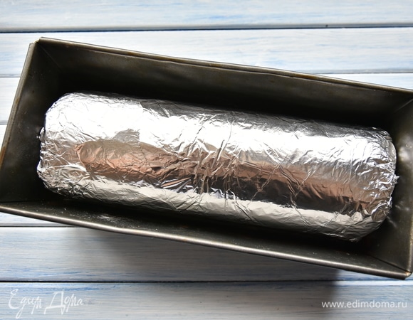 Завернуть рулет в несколько слоев фольги и уложить в форму. Запекать в разогретой до 180°C духовке около часа. Полностью остудить и положить в холодильник (лучше на ночь). Рулет готов.