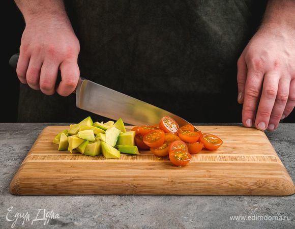 Помидоры черри разрежьте пополам, очищенное авокадо нарежьте крупными кубиками.