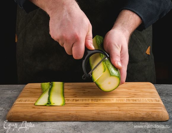 Цукини с помощью овощечистки нарежьте тонкими слайсами.