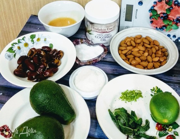 Подготовить необходимые продукты. Финики должны быть большими и мягкими. Мякоть из 2 больших спелых и мягких авокадо вынимают с помощью чайной ложки. Если у вас склонность к аллергии на мед и его содержащие продукты, можно заменить его на сироп топинамбура или агавы. Кокосовое масло предварительно оставить при комнатной температуре примерно на 3 часа, дать растаять. Масло должно быть органическое, холодного отжима, нерафинированное. Подготовить форму (разъемную или кольцо) диаметром 16 см с проложенной бумагой для выпечки для того, чтобы легко отделить торт от формы.