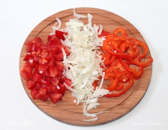 Мякоть помидора нарезать маленькими дольками. Лук очистить и нарезать как можно тоньше. Сладкий перец очистить от семян и нарезать тонкой соломкой. Кинзу крупно порубить.