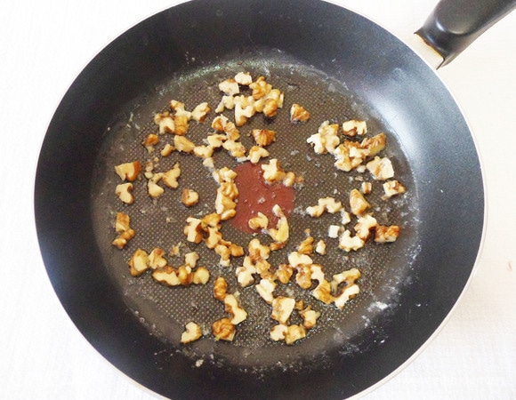 Грецкие орехи измельчить ножом и обжарить на сливочном масле 1 минуту.