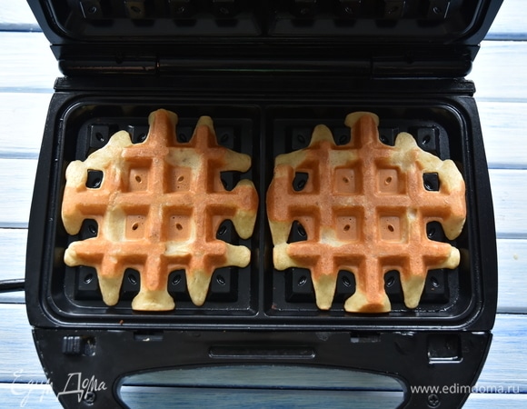 Разогреть вафельницу, однократно смазать небольшим количеством растительного масла. Выложить 2 ст. л. теста в каждую ячейку. Выпекать вафли до готовности.