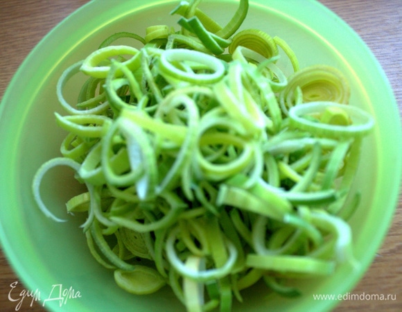 Нарезать зелень порея.