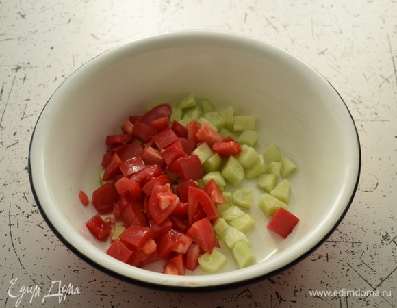 Огурцы очистить и нарезать кубиками. Нарезать помидоры. Выложить овощи в большую миску.
