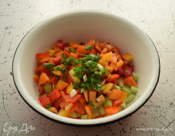 Добавить нарезанный лук и нарезанный кубиками перец.