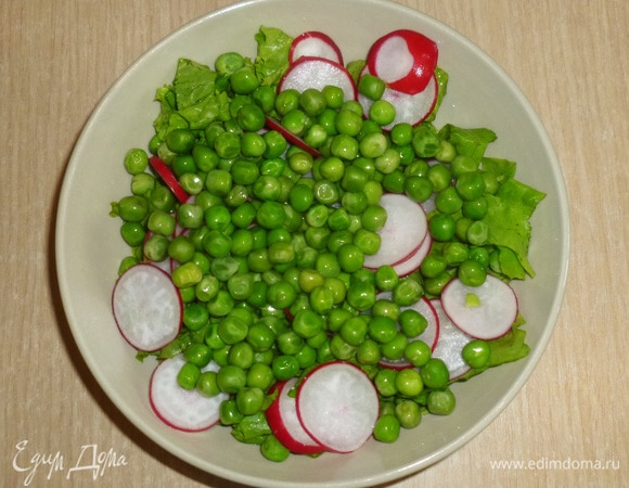 В салатник сложить нарезаные салатные листья, тонко нарезанный редис, добавить горошек.