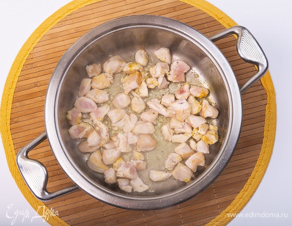 Разогреть сотейник с маслом для жарки. Обжаривать кусочки курицы 5 минут на среднем огне. Добавить куркуму, мелко порубленный чеснок (1 зубчик), соль, свежемолотый перец по вкусу.