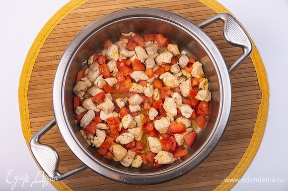 Добавить в сотейник томаты. Перемешать. Уменьшить нагрев плиты. Накрыть крышкой и готовить 3–4 минуты.