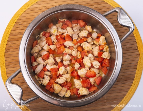 Добавить в сотейник томаты. Перемешать. Уменьшить нагрев плиты. Накрыть крышкой и готовить 3–4 минуты.