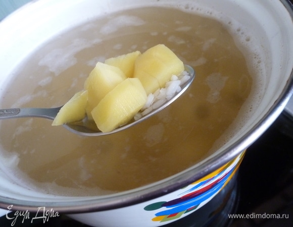 В бульон отправляем рис. Когда он закипит, положить картофель и варить, пока они не станут мягкими и не приготовятся.