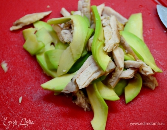 Отварить куриную грудку, очистить от шкурки и косточки авокадо, нарезать соломкой.