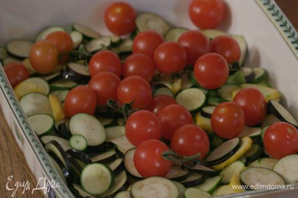 На овощи поместить помидоры на веточках, полить все оливковым маслом, посолить и поперчить.