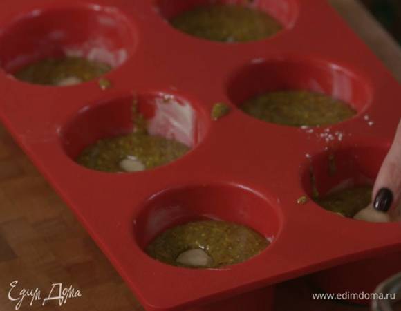 Формочки для маффинов смазать оставшимся сливочным маслом, выложить тесто, сверху поместить марципановые шарики и утопить их.