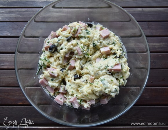 Репчатый лук нарезать мелким кубиком и пассеровать на сливочном масле. Сыр натереть на терке. Ветчину нарезать кубиком, зелень измельчить. Нарезать оливки. Соединить все компоненты начинки с тестом и хорошо перемешать.