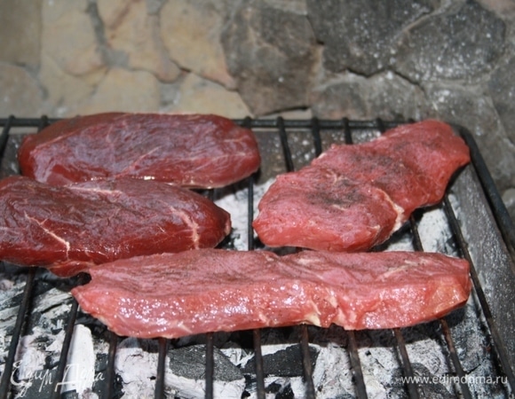 Затем на мангале распалить огонь, дождаться, когда дрова прогорят. Нам нужны стабильные «седые» угли. Решетку нужно выложить на мангал и хорошо прогреть. Затем выложить стейки так, чтобы они не касались друг друга (чтобы не было, так сказать, сокообмена).