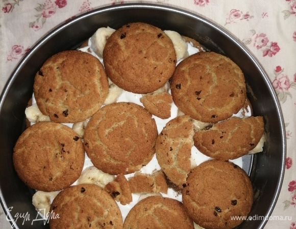 Можно использовать любое овсяное печенье, у меня с изюмом, устраивает по составу, ушло две пачки по 310 г каждая. Творог брала мягкий, обезжиренный. 4 коробки по 170 г хватает на три слоя. Можно использовать любой. Если используете обычный творог, то необходимо смешать его со сметаной до консистенции творожной массы. В разъемную форму укладываем первый слой печенья, пустые места заполняем кусочками. Подойдет любая глубокая форма. У меня диаметром 26 см.