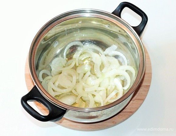 В казане или кастрюле с толстым дном разогреваем оливковое масло и обжариваем лук и мелко порубленный чеснок (1 зубчик) до прозрачности.