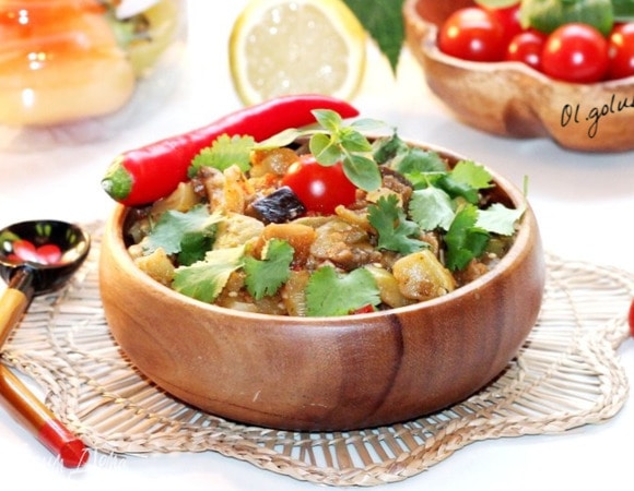 Затем добавляем лимонный сок, щепотку сахара и перемешиваем. Сверху на овощи кладем 2 зубчика чеснока и накрываем казан крышкой. Тушим овощи на маленьком огне приблизительно 30 минут или до готовности.