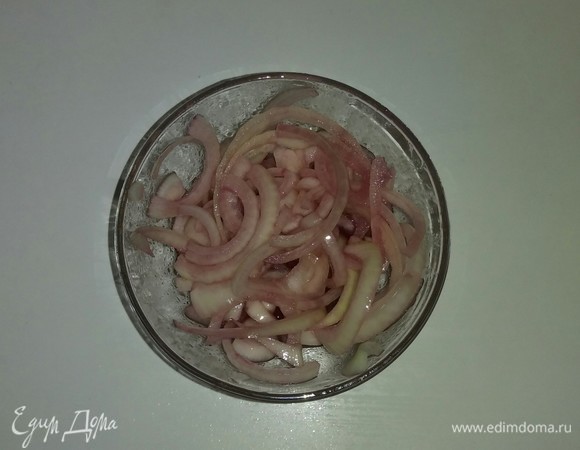 Нарезанный репчатый лук кладем в отдельную емкость и добавляем туда красное полусладкое вино, лимонный сок и оливковое масло. Все перемешиваем, закрываем пищевой пленкой и ставим на 1 час в холодильник.