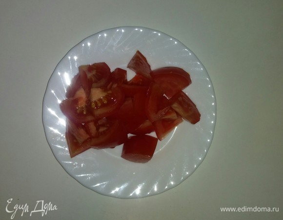 Помидор нарезаем дольками и затем разрезаем еще раз пополам.