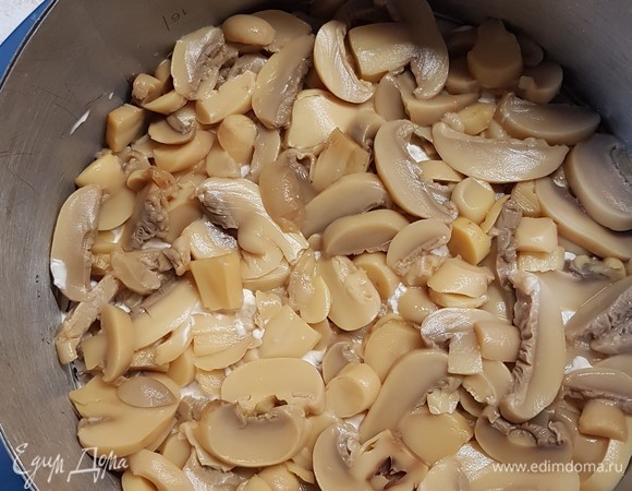 С консервированных шампиньонов слить воду и выложить сверху мясо, смазать майонезом.