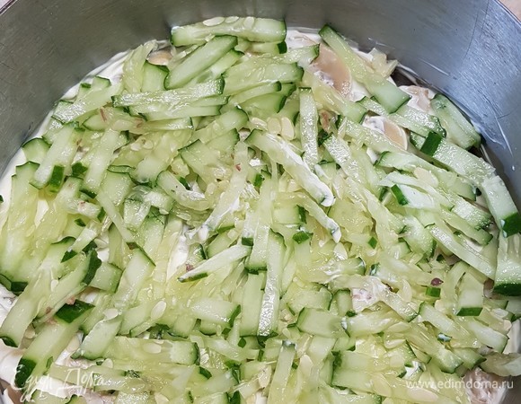 Огурец нарезать соломкой. Немного отжать и выложить на грибы, смазать майонезом.