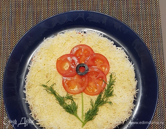 Сыр натереть на мелкой терке и выложить сверху помидор. Украсить по своему желанию. Поставить в холодильник, чтобы пропитался.