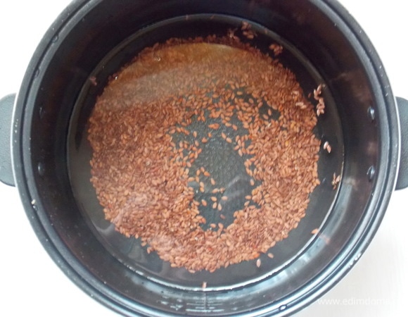 Воду вскипятить и влить в чашу мультиварки. Всыпьте семена льна, закройте крышку. Установите программу «Мультиповар», время — 70 минут, температура — 90°C.