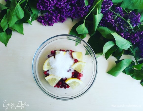 Засыпаем в тарелку клюкву, сахар и четверть лимона.