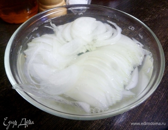 Залить лук кипятком на 1 минуту, чтобы избавиться от резкого вкуса и запаха. Время выдержки в горячей воде зависит от ваших желаний: чем дольше, тем мягче и нейтральнее на вкус он становится. Я делаю так, чтобы и легкий вкус лука оставался и чтобы он был хрустящий. Потом лук дойдет до нужного вкуса в томатно-масляном маринаде.