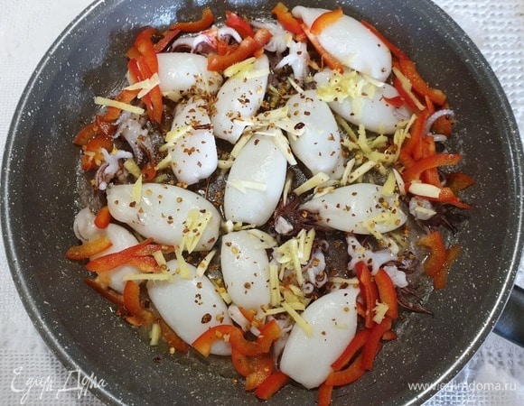 Добавляем к кальмарам имбирь и чеснок, нарезанные соломкой, болгарский перец и семена чили.