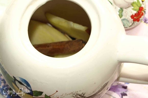 Чайник обдать кипятком. Отправляем в чайник палочку корицы, гвоздику и больше половины яблока, нарезанного тонкими дольками.