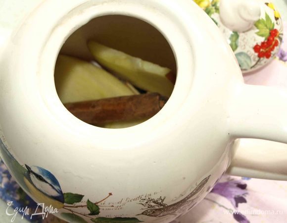 Чайник обдать кипятком. Отправляем в чайник палочку корицы, гвоздику и больше половины яблока, нарезанного тонкими дольками.