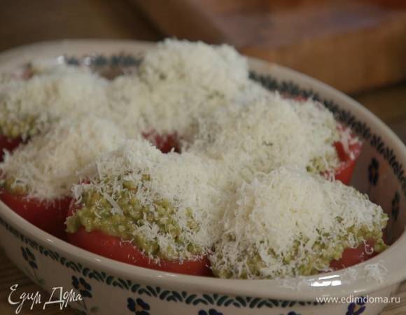 Выложить помидоры в жаропрочную керамическую форму, наполнить начинкой и посыпать натертым сыром.