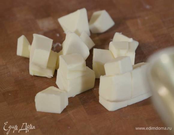 Нарезать 125 г предварительно охлажденного сливочного масла небольшими кубиками.
