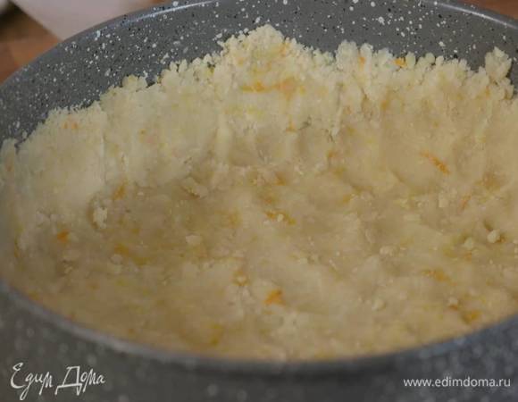 Дно разъемной формы для выпечки выстелить пищевой бумагой, смазать оставшимся сливочным маслом, выложить тесто и плотно утрамбовать в тонкий корж с бортиками.