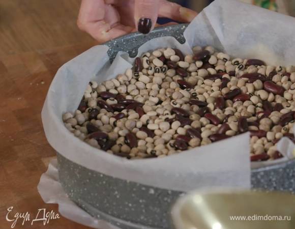 На песочный корж выложить бумагу для выпечки, всыпать любые бобовые и выпекать в разогретой духовке 20‒25 минут.