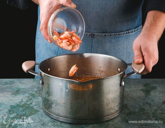 За пару минут до готовности положите в суп креветки и мелко нарезанную зелень.