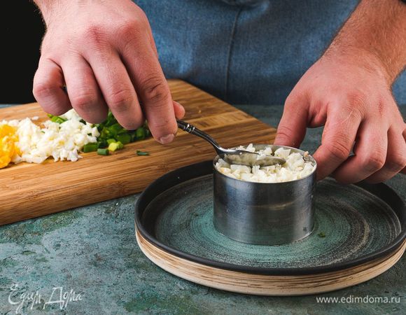 Далее — оливки, зеленый лук и белок. Каждый слой чередуйте с паштетом и плотно утрамбовывайте. Сверху выложите желток.