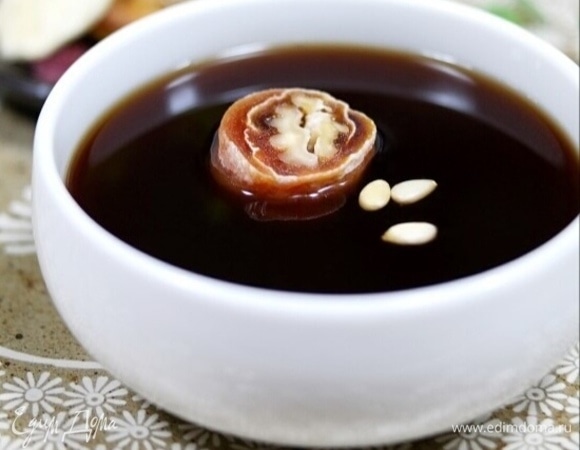 Остудите готовый напиток. Разлейте по чашкам. Нарежьте сушеную хурму на половинки и положите одну половинку в чашку с напитком. Добавьте несколько кедровых орешков. Оставьте настаиваться на 60 минут. Либо можно подавать напиток без хурмы и орешков. Храните напиток в холодильнике.