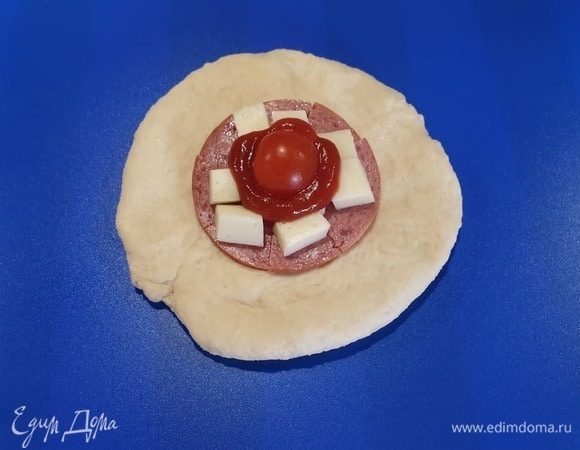 На салями кладем моцареллу, чайную ложку томатного соуса и половинку черри.
