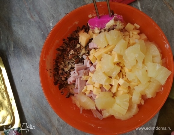 Ветчину, ананасы и сыр нарезать мелкими кусочками. Орехи порубить. Все наполнители добавить в тесто, перемешать. Получится довольно густая масса.