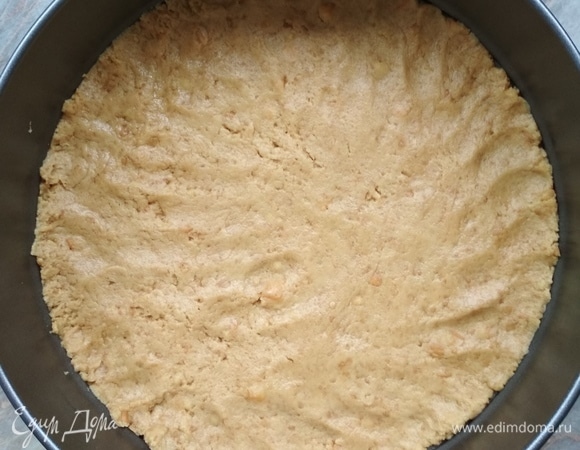 Форму застилаем бумагой. В ней ровно по дну распределить основу и поставить в холодильник.