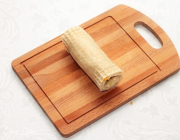 Плотно прижимая сосиску к начинке, сворачиваем вафлю в рулет. Даем время остыть рулету.