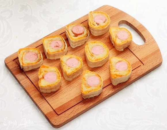 Острым ножиком разрезаем каждый рулет на несколько частей.