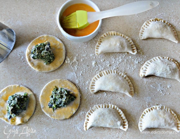 Взбитым яйцом слегка смажьте края теста, в серединку выложите по 1 ст. л. начинки. Сложите тесто пополам, прижимая края друг к другу. С помощью вилки еще раз пройдитесь по краю поверхности пирожков, чтобы во время выпекания они уж точно не раскрылись.