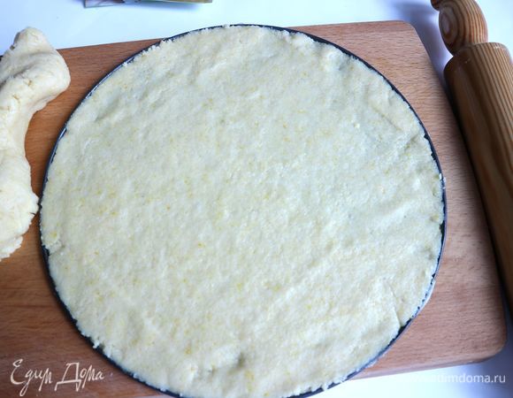 Духовку разогреть до 220°C. Отделить от теста кусочек для бортов. Тесто для основы раскатать прямо на донышке разъемной формы, смазанной сливочным маслом. Борта формы также смазать сливочным маслом.