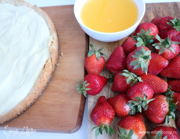 Ванильный крем выложить на корж и разровнять. Клубнику помыть, откинуть на дуршлаг. Дать обсохнуть, разложив на полотенце. Для приготовления желе выжать сок из одного апельсина, добавить воды, чтобы общее количество жидкости составило 230 грамм. Из быстрорастворимого желатина, сахара и жидкости сварить желе согласно инструкции на упаковке с желатином. Я в желатин добавила еще 1 кофейную ложку порошка агар-агар, учитывая то, что кислые соки снижают рабочие свойства желатина. Дать полностью остыть.